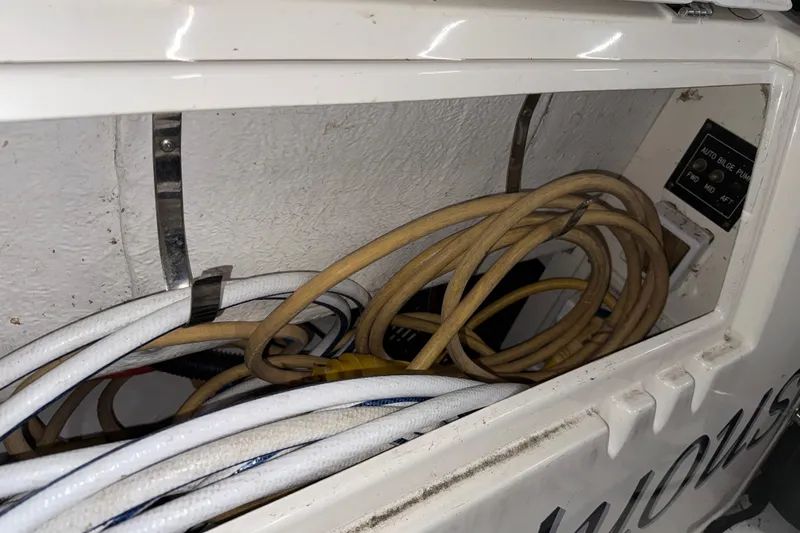 Slide: The Image of 2004 Cruisers Yachts 340 Express wiring compartment with cables and bilge pump controls. - 44