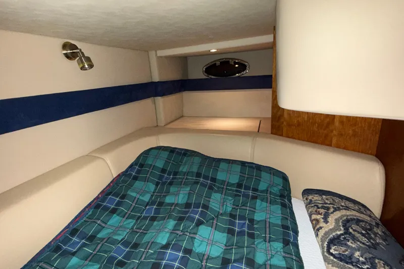 Slide: The Image of Interior cabin of 2004 Cruisers Yachts 340 Express with plaid bedding and cozy lighting. - 9
