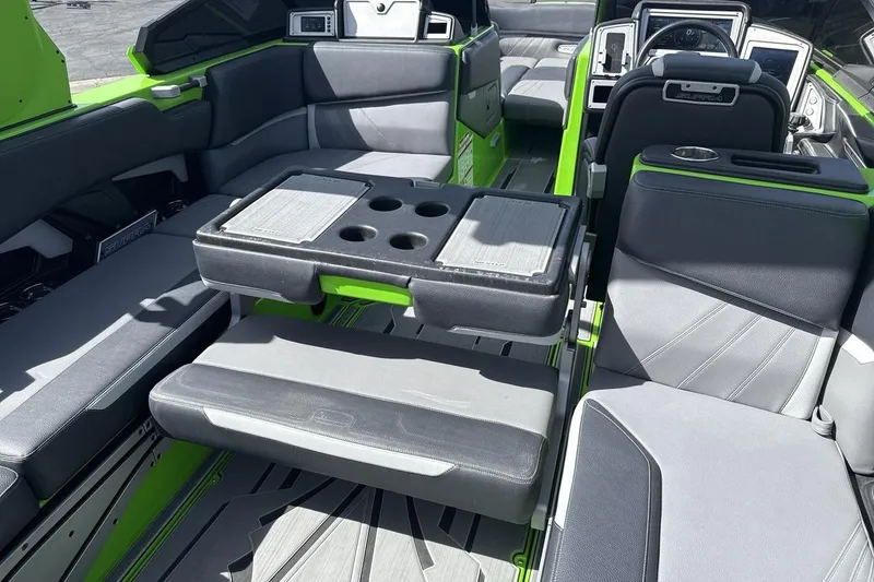 Slide: The Image of 2022 Supra SA 450 boat interior with gray and green seating and cup holders. - 23