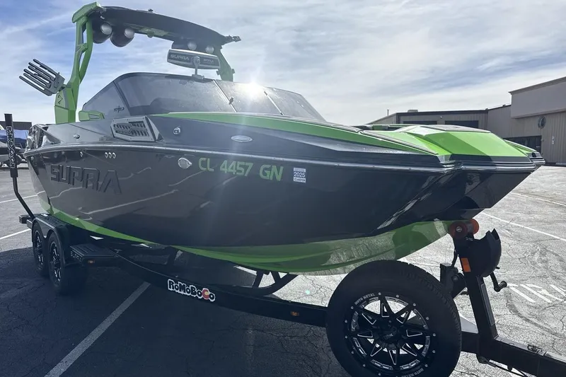 Slide: The Image of 2022 Supra SA 450 boat in green and black on a trailer, parked outdoors. - 7