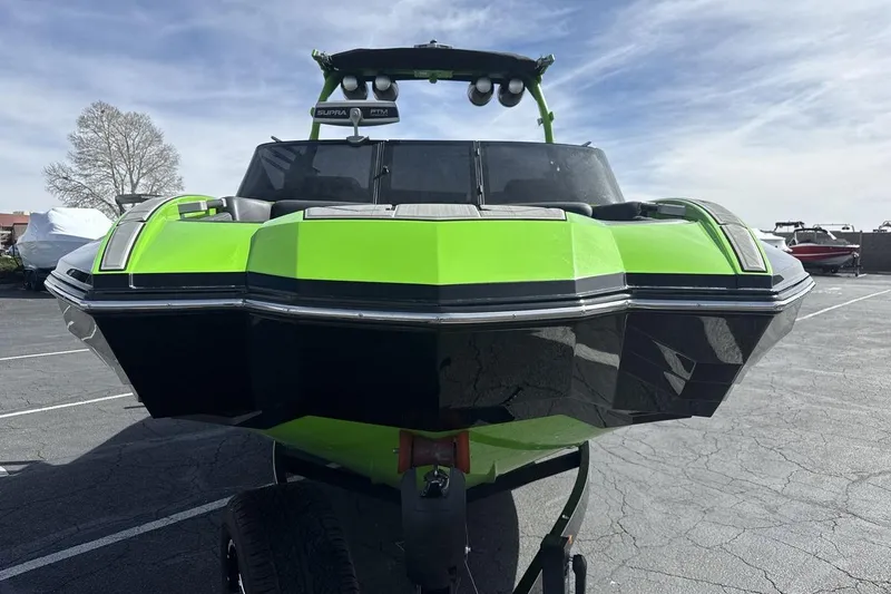 Slide: The Image of 2022 Supra SA 450 boat in vibrant green and black, parked outdoors on a sunny day. - 8