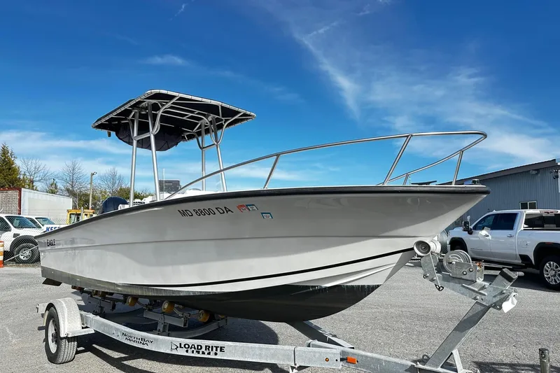The Image of 2004 Angler Eagle Center Console boat on trailer under clear blue sky. - 0
