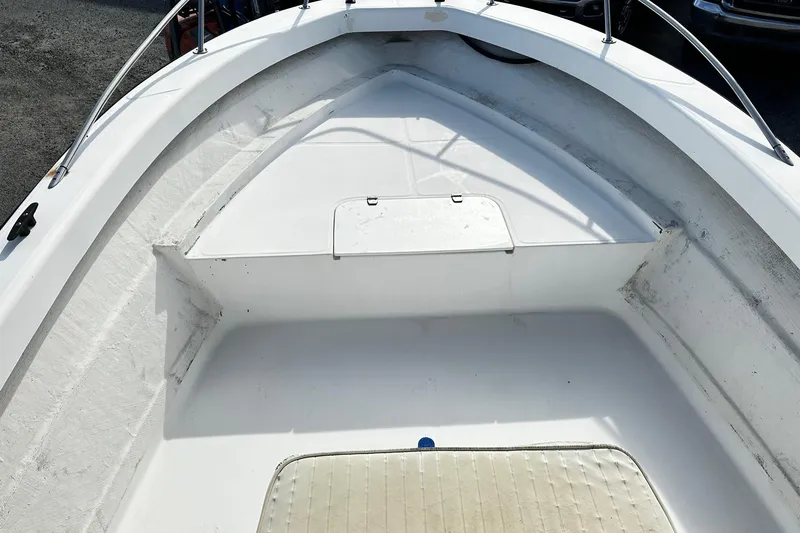 Slide: The Image of 2004 Angler Eagle Center Console boat interior with white deck and storage compartment. - 7