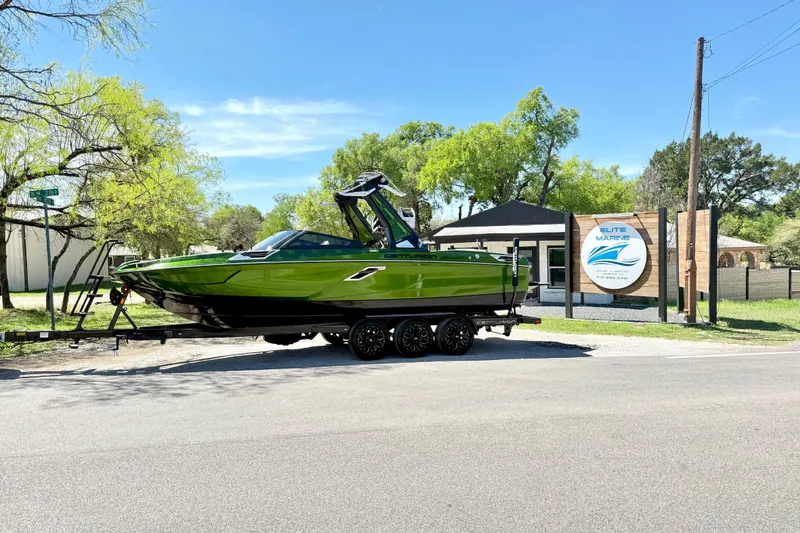 The Image of 2021 Centurion Ri245 boat in vibrant green on a trailer at Elite Marine dealership. - 1