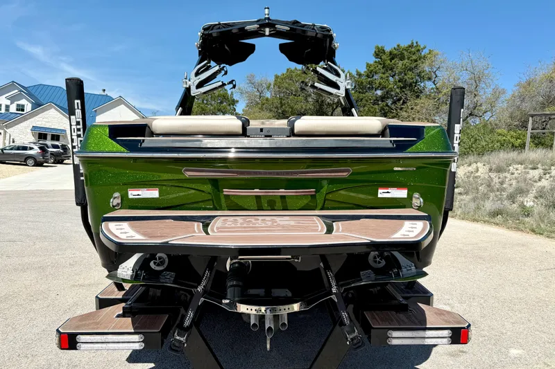 Slide: The Image of 2021 Centurion Ri245 boat, green exterior, rear view with swim platform and wakeboard tower. - 13