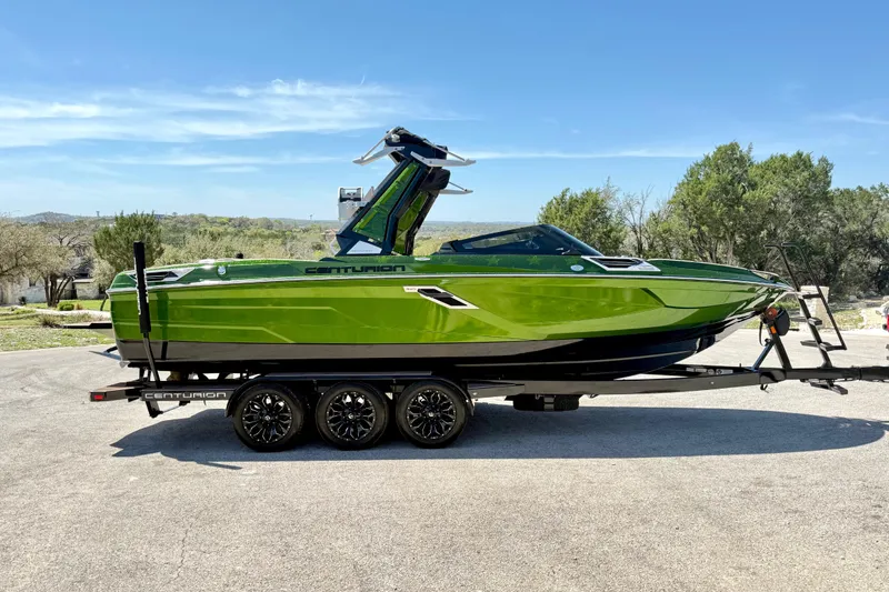 Slide: The Image of 2021 Centurion Ri245 boat in vibrant green on a trailer, outdoors. - 16