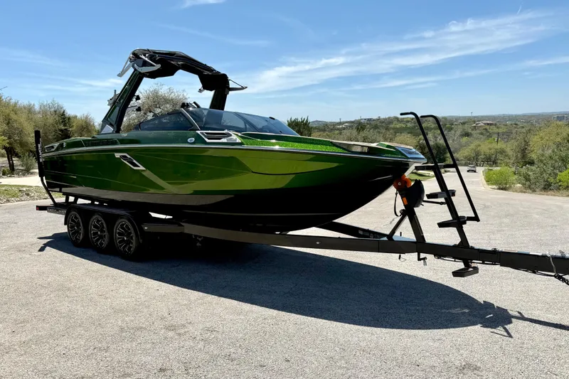 Slide: The Image of 2021 Centurion Ri245 boat in vibrant green on a trailer, parked outdoors. - 17