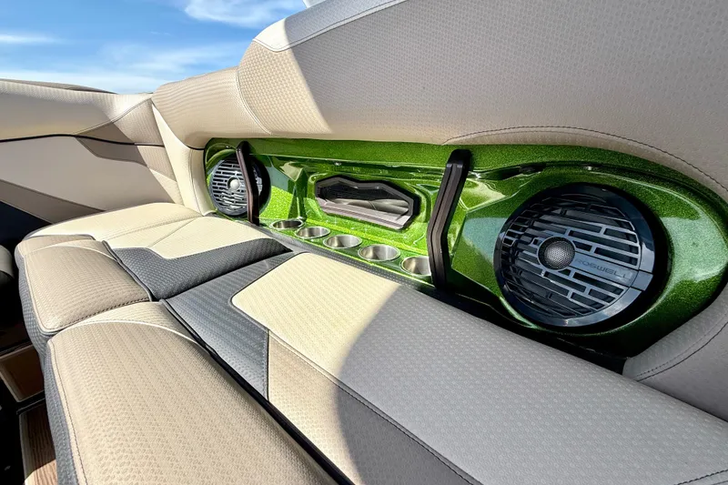 Slide: The Image of 2021 Centurion Ri245 boat interior with green accents, speakers, and cup holders. - 24