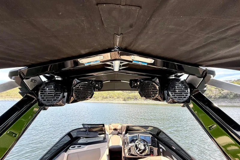 Slide: The Image of 2021 Centurion Ri245 boat interior with speakers and steering wheel, overlooking a serene lake. - 34