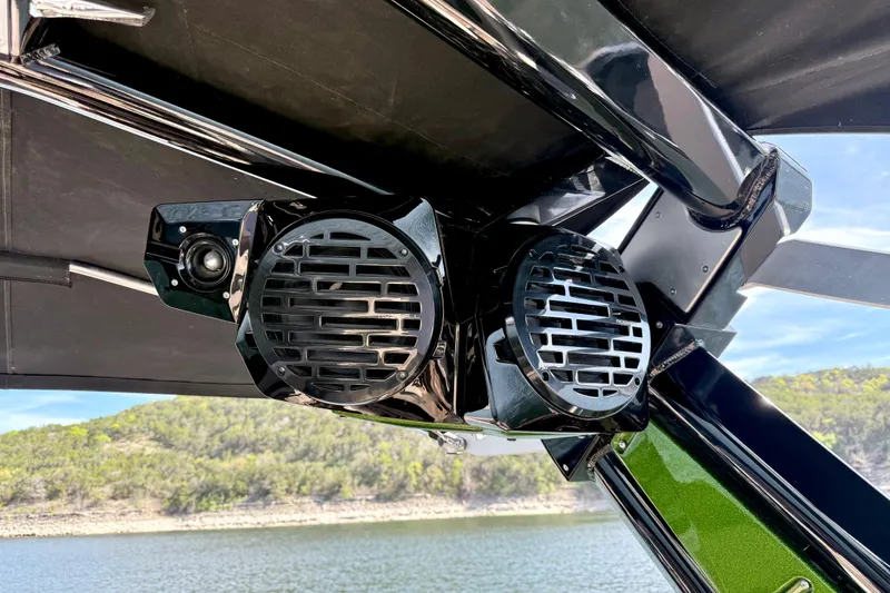 Slide: The Image of 2021 Centurion Ri245 boat speakers mounted under canopy by a lake. - 35