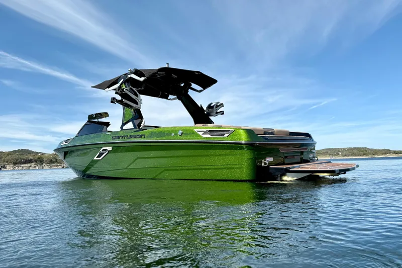 Slide: The Image of 2021 Centurion Ri245 boat in vibrant green on calm water under clear blue sky. - 6