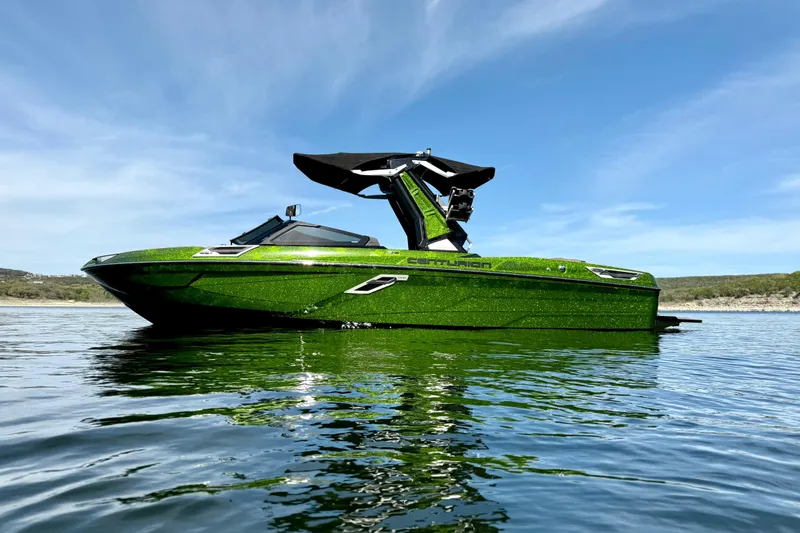 Slide: The Image of 2021 Centurion Ri245 boat in vibrant green on calm water under blue sky. - 7