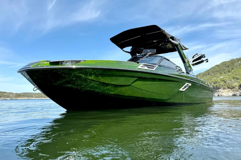 Slide: The Image of 2021 Centurion Ri245 boat in vibrant green on calm water under blue sky. - 8