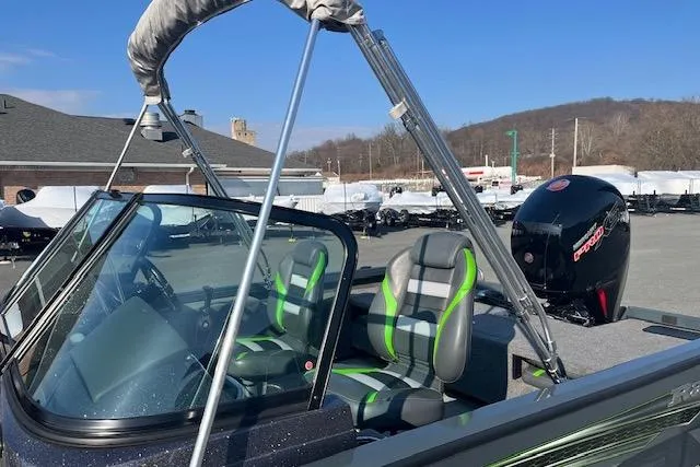 Slide: The Image of 2023 Ranger VS1782SC Reata boat with green-accented seats and a powerful outboard motor. - 13