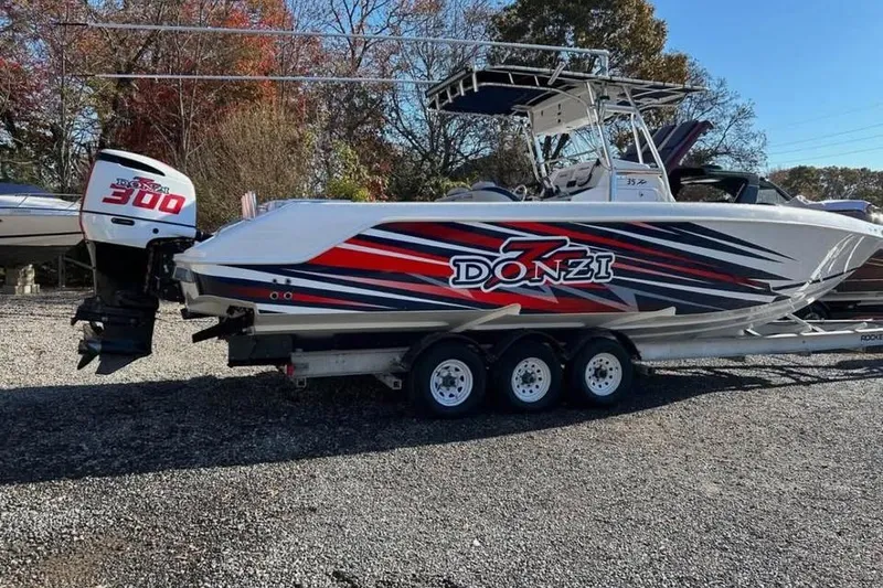 The Image of 2001 Donzi 35 ZF boat on trailer with vibrant graphics and powerful outboard motor. - 0