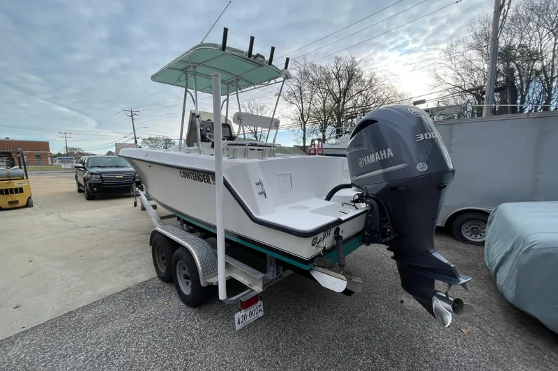 Slide: The Image of 1999 Contender 23 CC boat with Yamaha 300 engine on trailer, parked outdoors. - 10