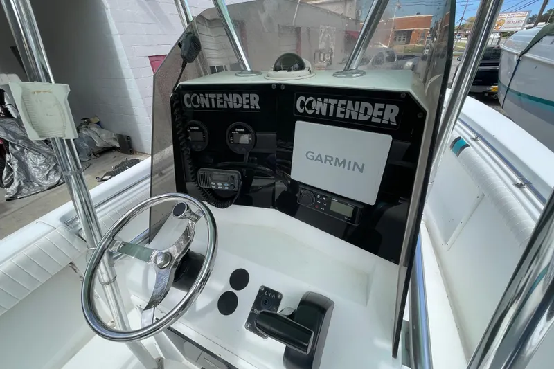 Slide: The Image of 1999 Contender 23 Open boat dashboard with Garmin navigation system and steering wheel. - 12