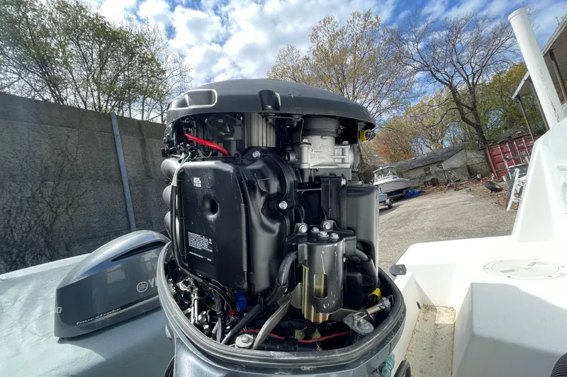 Slide: The Image of Open Yamaha outboard engine on a 1999 Contender 23 Open boat, parked outdoors. - 16