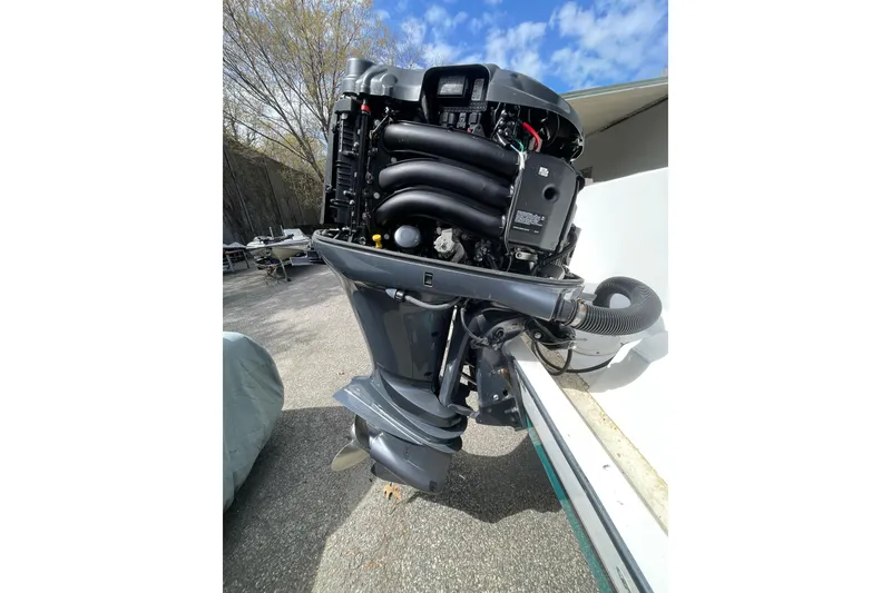 Slide: The Image of Outboard motor on a 1999 Contender 23 Open boat, parked outdoors. - 18