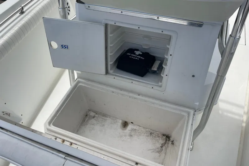 Slide: The Image of 1999 Contender 23 Open boat storage compartments with first aid kit visible. - 20