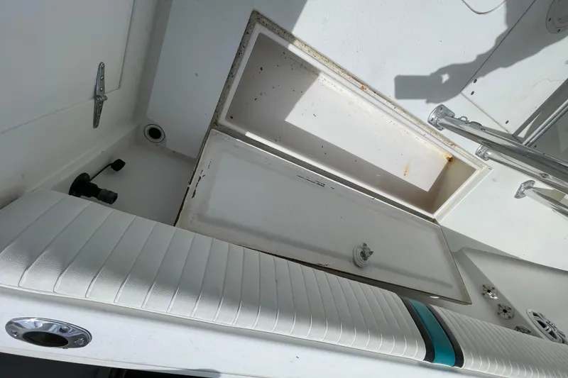 Slide: The Image of 1999 Contender 23 Open boat interior with open storage compartment and cushioned seating. - 22