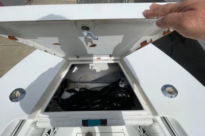 Slide: The Image of Open storage compartment on a 1999 Contender 23 Open boat, showing ropes and equipment. - 24