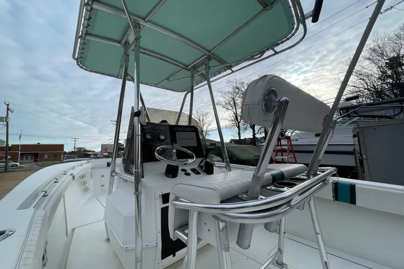 Slide: The Image of 1999 Contender 23 CC boat interior with steering console and seating under canopy. - 4