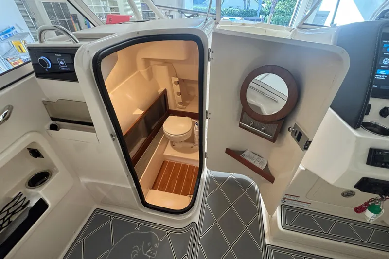 Slide: The Image of 2022 Grady-White Freedom 275 boat interior with open bathroom door and modern amenities. - 25