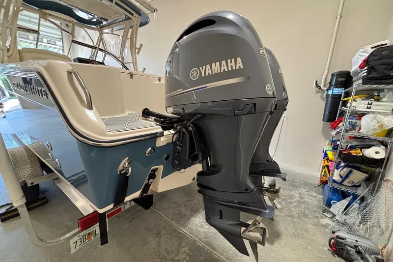 Slide: The Image of 2022 Grady-White Freedom 275 boat with dual Yamaha outboard motors in a garage. - 31