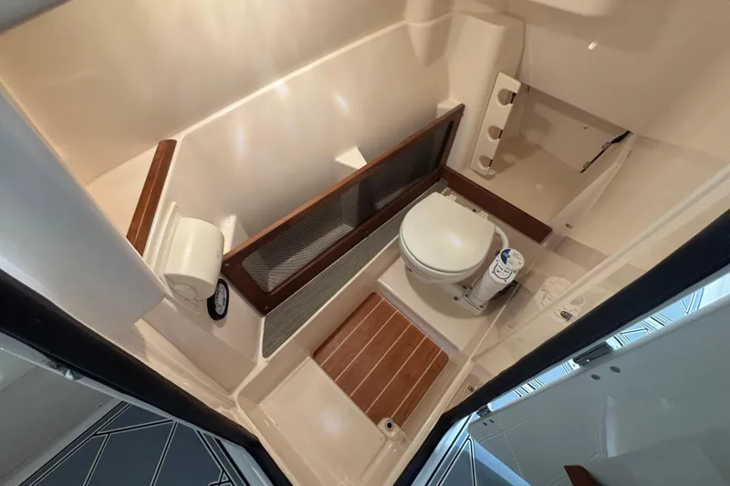 Slide: The Image of 2022 Grady-White Freedom 275 boat bathroom interior with toilet and wooden flooring. - 5