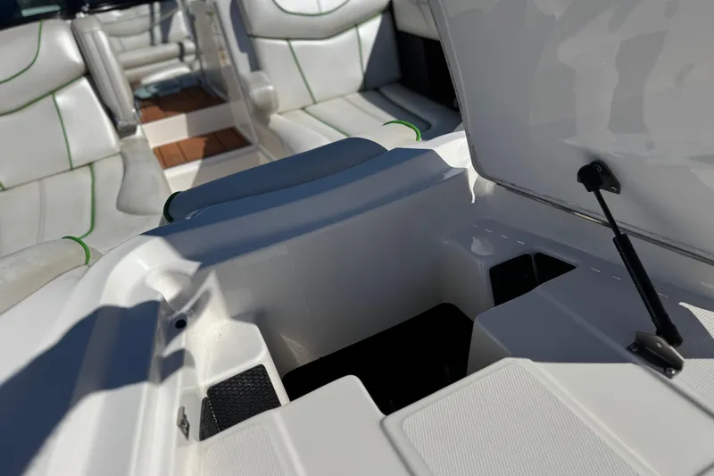 Slide: The Image of 2013 MasterCraft XStar boat interior with open storage compartment and white seating. - 12