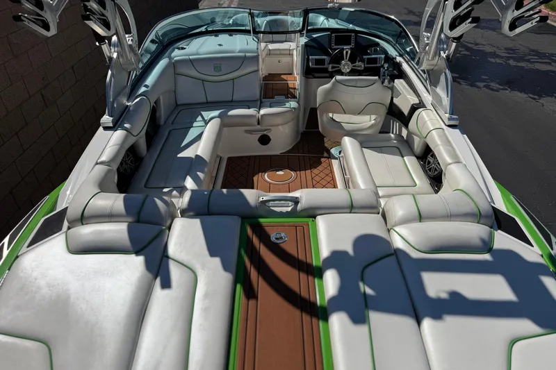 Slide: The Image of 2013 MasterCraft XStar boat interior with luxurious white seating and green accents. - 14