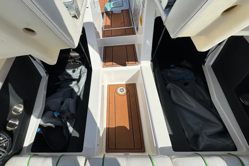 Slide: The Image of 2013 MasterCraft XStar boat interior with storage compartments and teak flooring. - 17