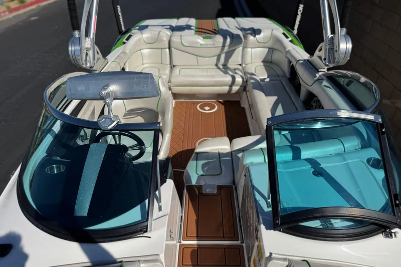Slide: The Image of 2013 MasterCraft XStar boat interior with white seating and wooden flooring. - 18