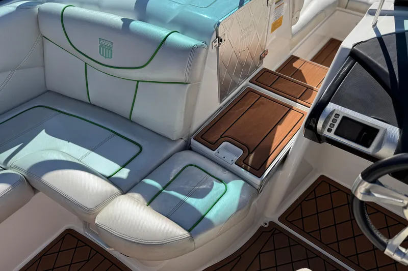 Slide: The Image of 2013 MasterCraft XStar interior with white and green seating, wood accents, and control panel. - 21