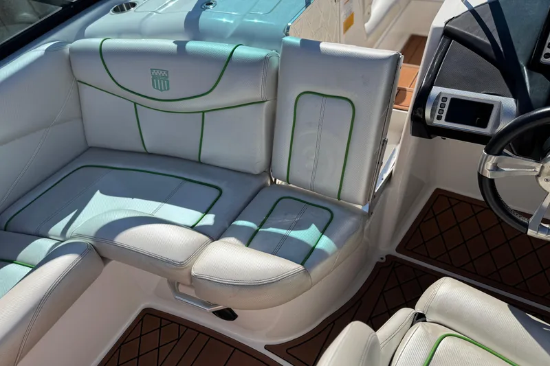Slide: The Image of 2013 MasterCraft XStar interior with white and green seating, modern dashboard, and steering wheel. - 22