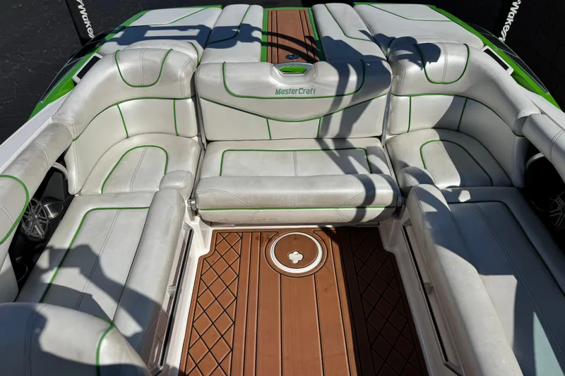 Slide: The Image of Interior of a 2013 MasterCraft XStar boat with white seating and wood flooring. - 23