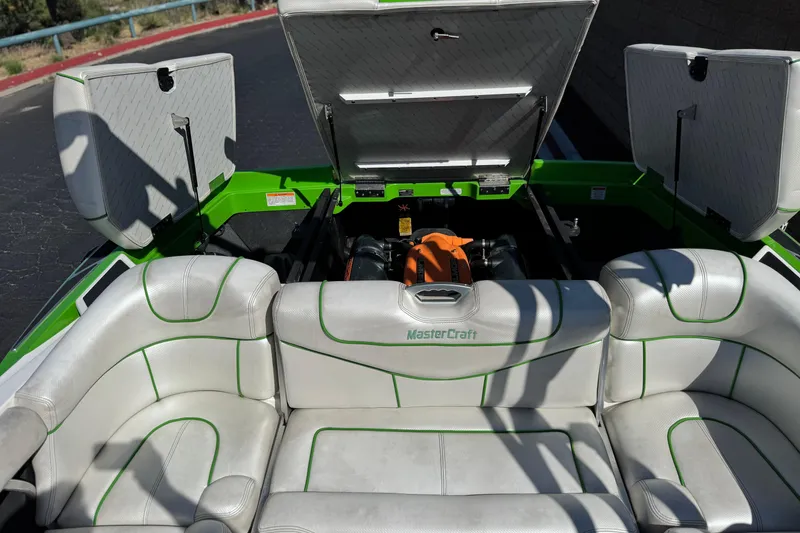 Slide: The Image of 2013 MasterCraft XStar boat interior with open engine compartment and white seating. - 24
