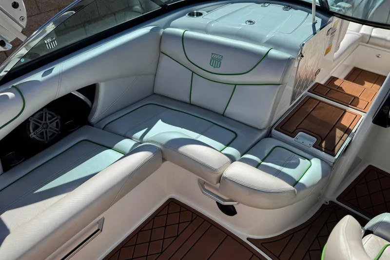 Slide: The Image of 2013 MasterCraft XStar boat interior with white and green seating, wood accents, and speaker. - 27
