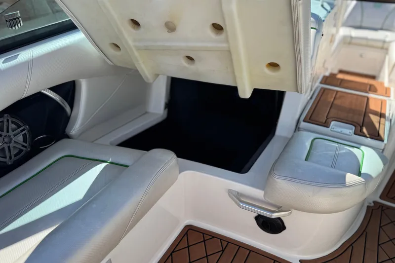 Slide: The Image of 2013 MasterCraft XStar interior with open storage compartment and cushioned seating. - 28