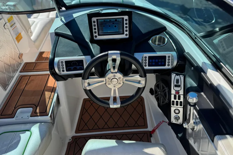 Slide: The Image of 2013 MasterCraft XStar boat dashboard with steering wheel and control panels. - 31