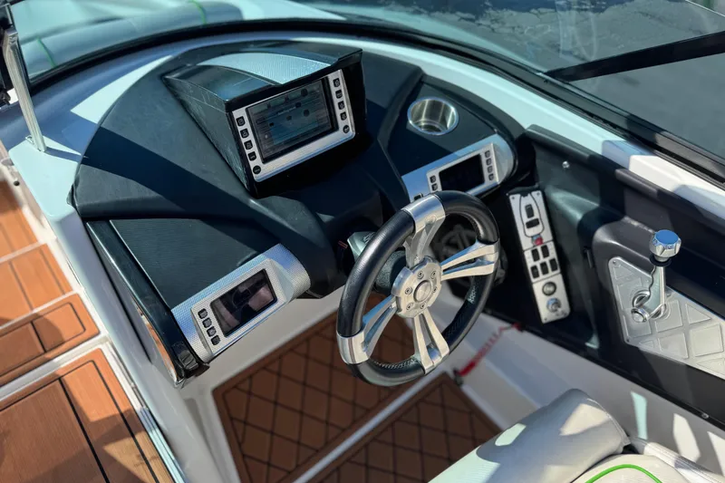 Slide: The Image of 2013 MasterCraft XStar boat dashboard with modern controls and steering wheel. - 32