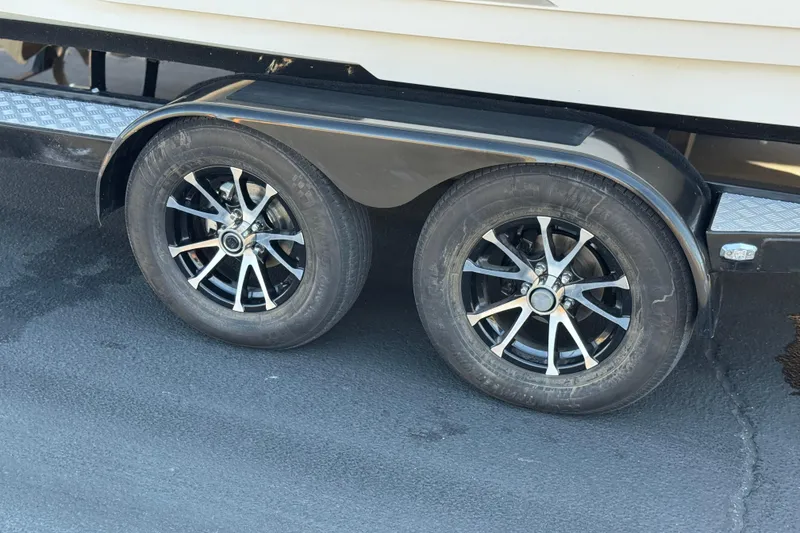 Slide: The Image of Trailer wheels of a 2013 MasterCraft XStar boat on pavement. - 35