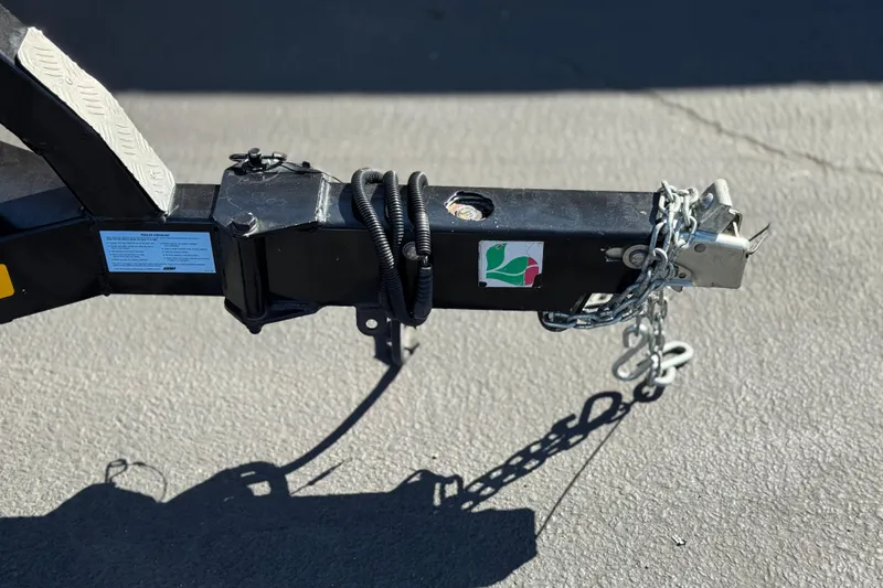 Slide: The Image of Trailer hitch of a 2013 MasterCraft XStar with safety chains on asphalt. - 36