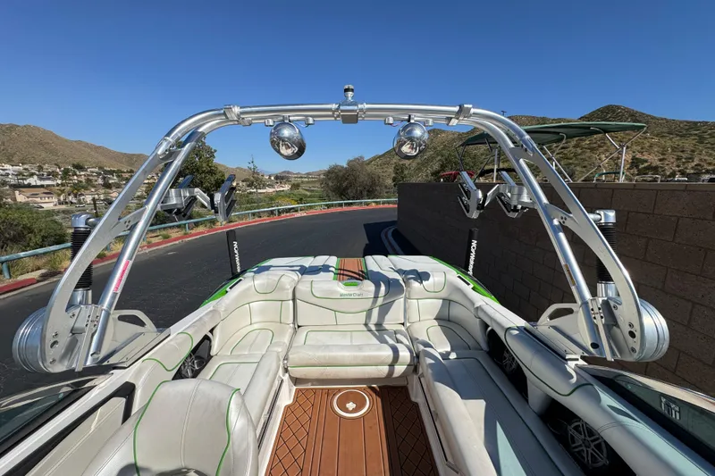 Slide: The Image of 2013 MasterCraft XStar boat interior with wakeboard tower, parked on a scenic road. - 37