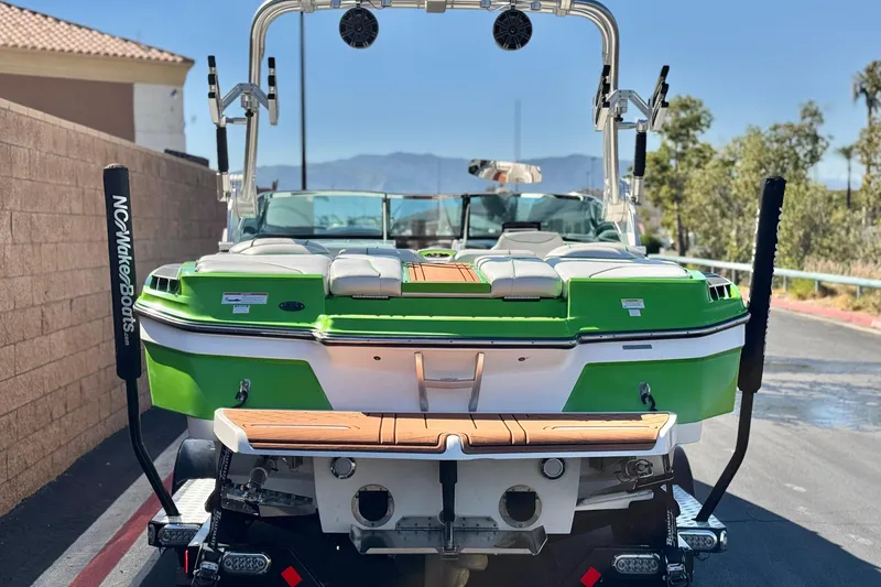 Slide: The Image of 2013 MasterCraft XStar boat with green and white exterior, parked on a sunny day. - 5