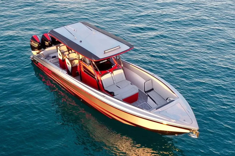 Slide: The Image of 2024 Nor-Tech 340 Sport Center Console boat on clear blue water. - 3
