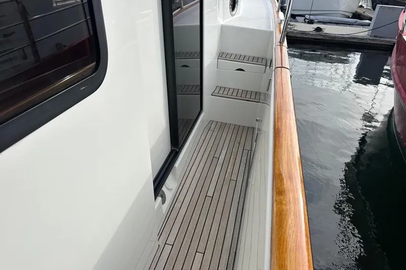 Slide: The Image of 2015 Beneteau Swift Trawler 44 deck with wooden railing, docked at marina. - 11