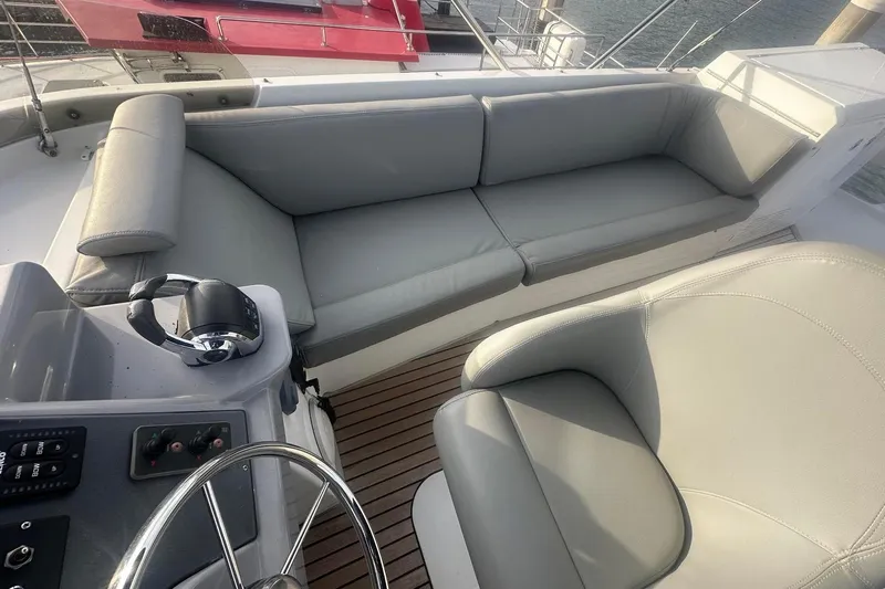 Slide: The Image of 2015 Beneteau Swift Trawler 44 cockpit with plush seating and steering wheel. - 19