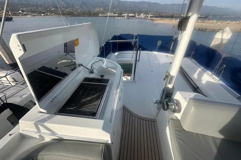 Slide: The Image of 2015 Beneteau Swift Trawler 44 deck with grill, overlooking scenic marina and mountains. - 24